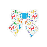 Sailor Bow in a dog friendly pattern that shows party images like balloons and confetti. The center is made from solid blue trim. It's complete with attached elastic loops on the back to secure on dog collar.